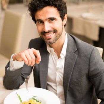 Handsome man eating at the restaurant