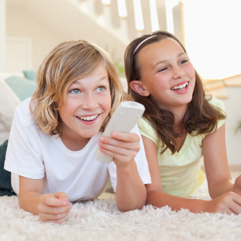 Siblings lying on the floor watching tv