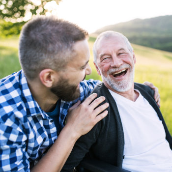 amused father with his son laughing in the park