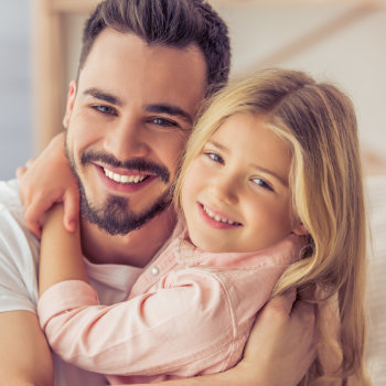 smiling father hugs his daughter