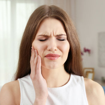 suffering brunette girl holds her jaw