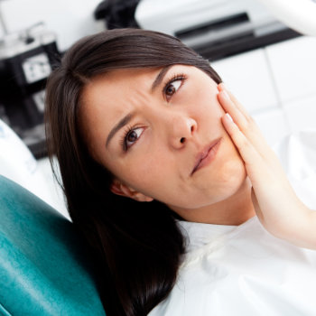 woman with toothache sitting in the dental chair