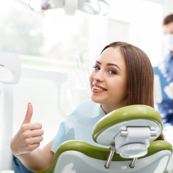 young brunette sitting happy in the dental chair